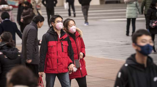 Pedestrians wearing masks walk in Shanghai, China, on Jan. 23.
