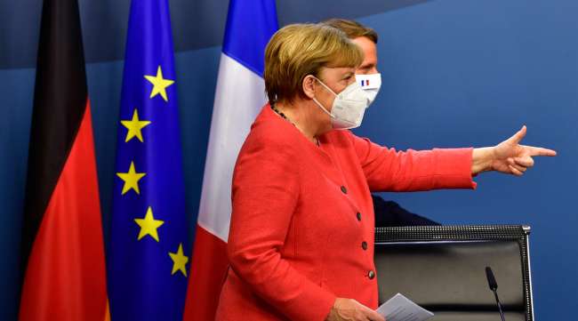 German Chancellor Angela Merkel, left, and French President Emmanuel Macron walk onto the podium prior to a media conference at the end of an EU summit in Brussels on July 21.