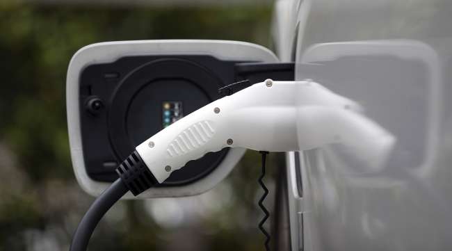 An electric vehicle charger is plugged into a vehicle.