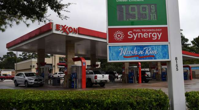 Vehicles refuel at an Exxon Mobil Corp. gas station in Houston on Oct. 28. (Callaghan O'Hare/Bloomberg News)