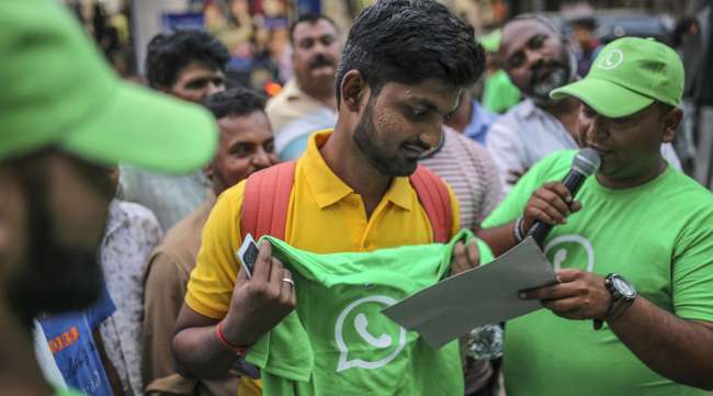 A spectator holds a branded t-shirt during a roadshow for Facebook's WhatsApp messaging service in Pune, India, in October 2018.