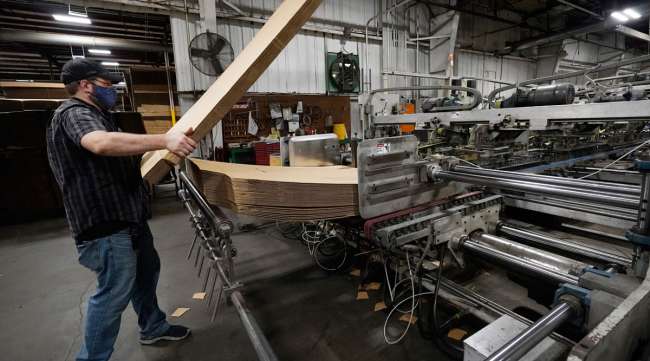 A supervisor at a packaging company in Jackson, Miss., loads up a finishing machine. (Rogelio V. Solis/Associated Press)