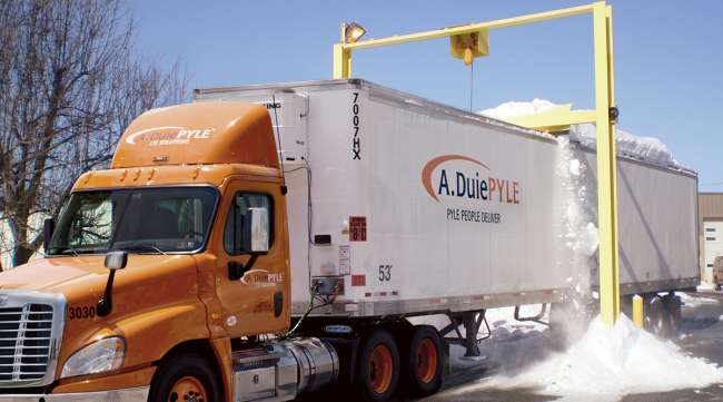 A. Duie Pyle truck moves underneath a snow scraper