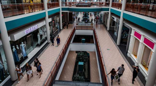 Shoppers walk through a mall in Syracuse, N.Y., on July 10.