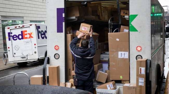 A FedEx worker unloads packages from a truck in New York on Dec. 2, 2019.