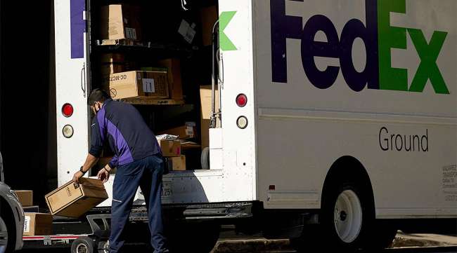A FedEx delivery truck is unloaded