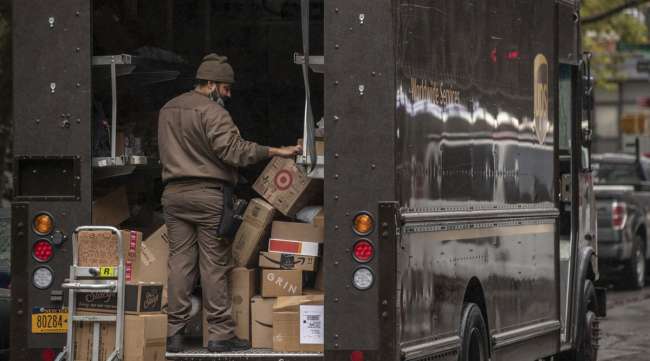 A UPS driver sorts boxes in the back of a delivery van in New York. (Victor J. Blue/Bloomberg News)