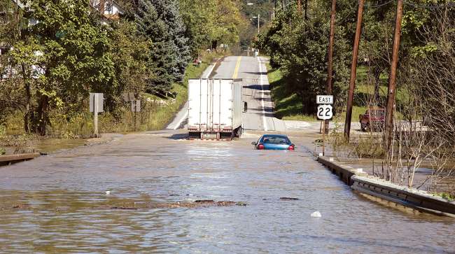 Vehicles try to cross flooded road