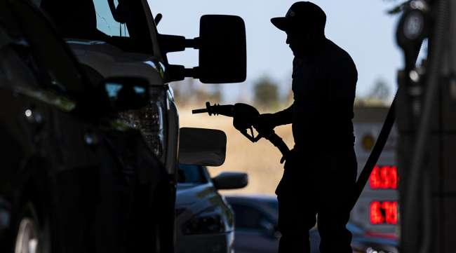 A customer holds a fuel nozzle at a Shell gas station in Hercules, Calif.