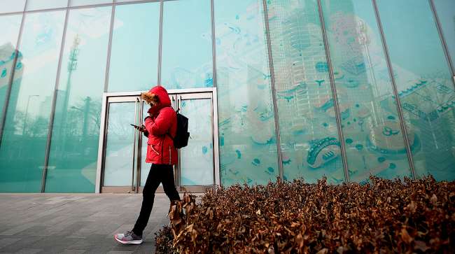 Man walking by empty storefront in Beijing's Central Business District