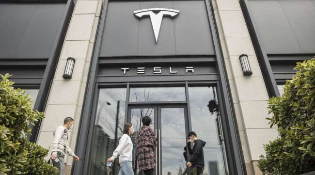 Pedestrians walk past a Tesla dealership in Shanghai, China, on April 6.