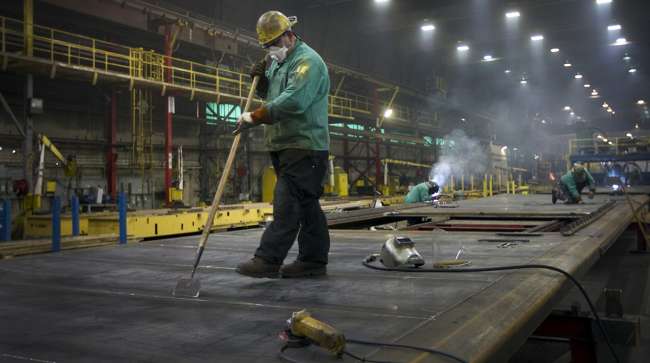 A welder works on sides for refrigerated rail cars at the Gunderson Rail Car Plant in Portland, Ore.