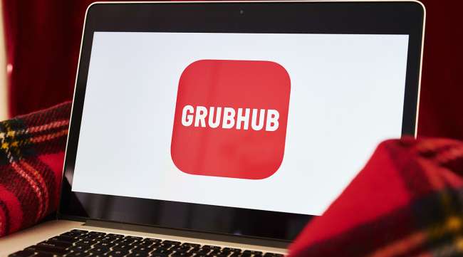 The logo for the Grubhub Inc. application is displayed on an Apple Inc. laptop computer