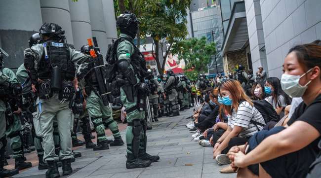 Demonstrators are detained by riot police in front of a shopping mall in Hong Kong on May 27.