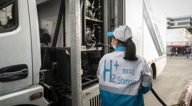 An attendant fills a truck with compressed hydrogen at a filling station in Shanghai.