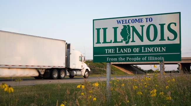 Truck passing Welcome to Illinois sign