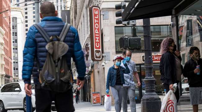 Pedestrians wearing masks walk near a Chipotle in San Francisco on July 20.
