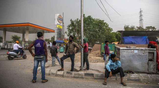 People stand next to a gas station during a partial lockdown in New Delhi, India, on May 14.