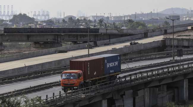A truck transports shipping containers from the Jawaharlal Nehru Port in Maharashtra, India, on March 30.