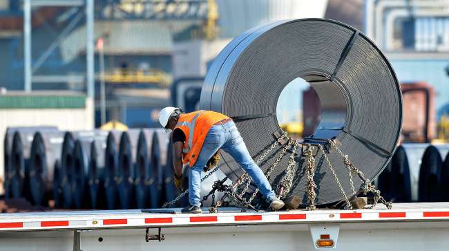 A truck driver chains down a roll of steel to his flatbed at the NUCOR Steel Gallatin plant in Ghent, Ky.