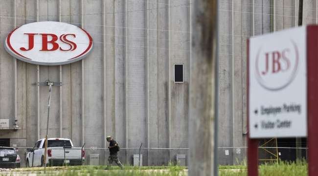 A person walks outside the JBS Beef Production facility in Greeley, Colo., on June 1.