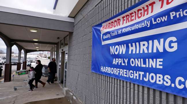 A "Now Hiring" sign hangs on the front wall of a Harbor Freight Tools store in New Hampshire.