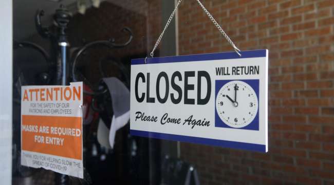 A closed sign hangs in the window of a barber shop in Burbank, Calif., on July 18.