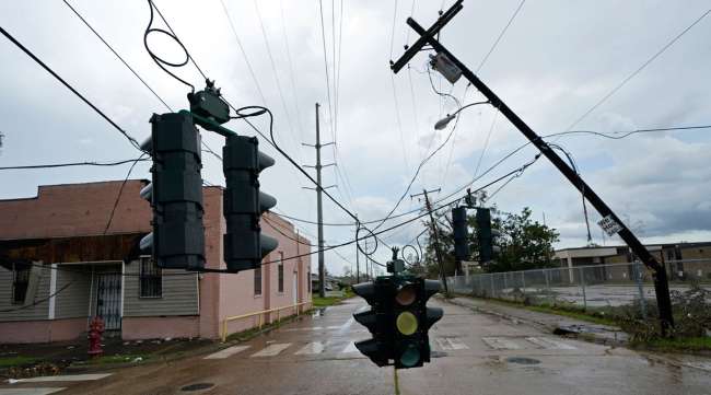 Traffic signals dangle close to the roadway from broken utility poles in Lake Charles, La. on Aug. 30.