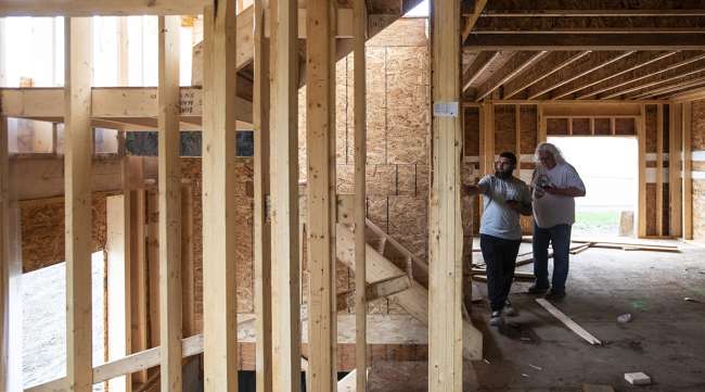 Workers inspect a home under construction by Akash Homes in Edmonton, Alberta, Canada.