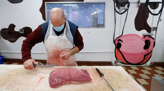 John Warminski prepares meat at Ronnie's Quality Meats in Detroit on April 29.