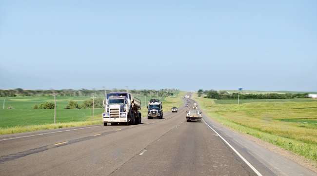 Vehicles travel on road in North Dakota