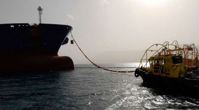 The Gemini Star oil tanker, owned by a subsidiary of Saudi Aramco, is seen with a tug boat.