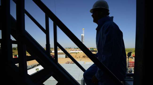 The silhouette of a contractor is seen walking up stairs at an oil rig site in Colorado.