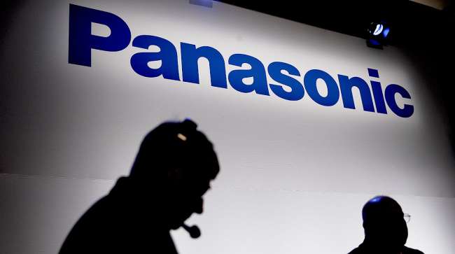 Men silhouetted against Panasonic sign