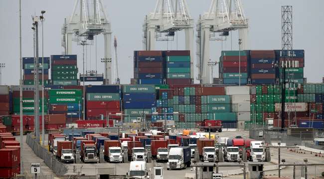 Cargo trucks wait in line at the Port of Long Beach, in Long Beach, Calif.;