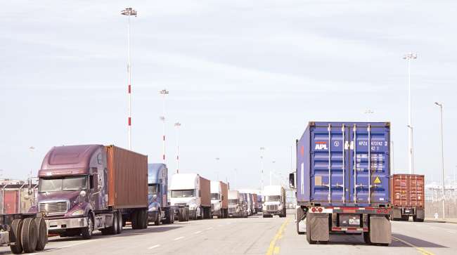 trucks line Middle Harbor Road waiting to enter the docks at the Port of Oakland.