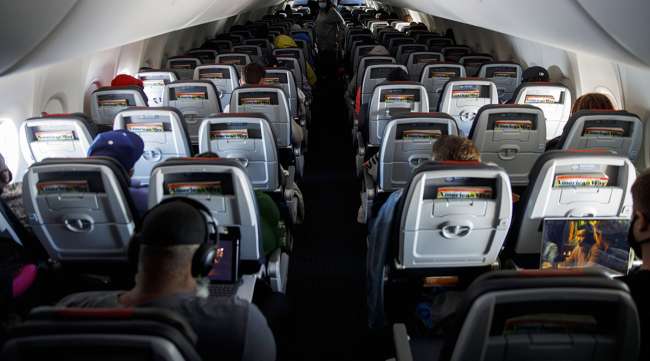 Passengers wear protective masks on an American Airlines flight. (Patrick T. Fallon/Bloomberg News)