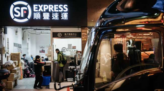 Employees handle packages at an SF Express store in Hong Kong. (Anthony Kwan/Bloomberg News)