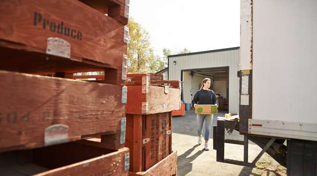 Woman loads truck with produce