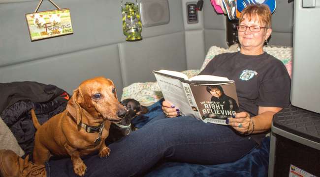Woman reading with dog in sleeper berth