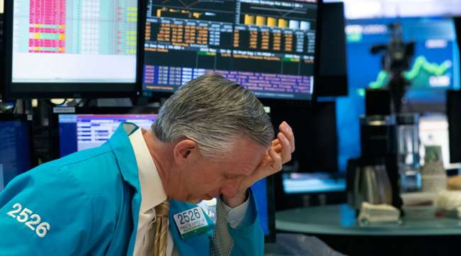 A trader holds his hand to his head after trading was halted at the New York Stock Exchange on March 18.