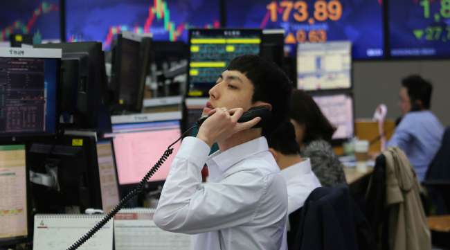 A currency trader talks on the phone at the foreign exchange dealing room of the KEB Hana Bank headquarters in Seoul, South Korea, on April 22.