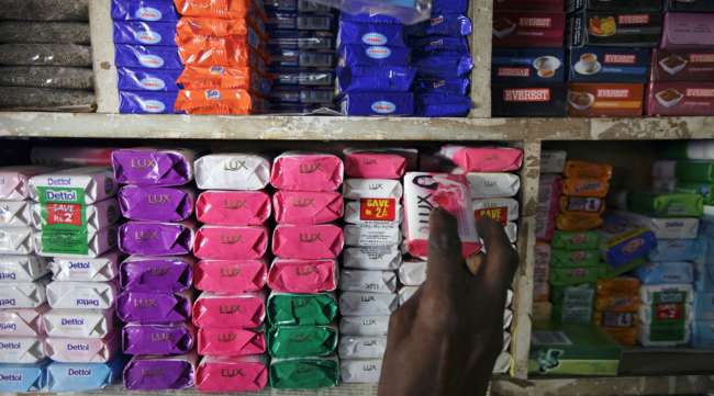A man takes a bar of soap off a store shelf in Mumbai, India.