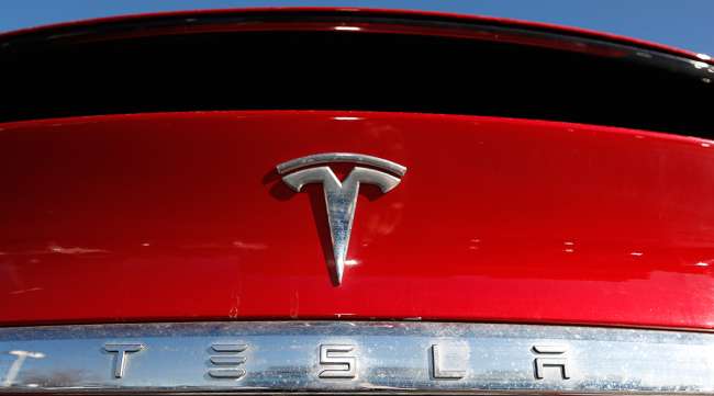The Tesla logo sits on a Model X at a Tesla dealership in Littleton, Colo.
