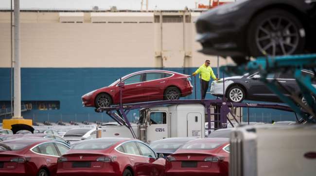 Tesla vehicles are unloaded from car carriers before being shipped from the Port of San Francisco.
