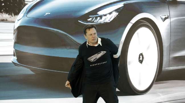 Elon Musk removes his jacket during the Tesla China-made Model 3 delivery ceremony in Shanghai in January.