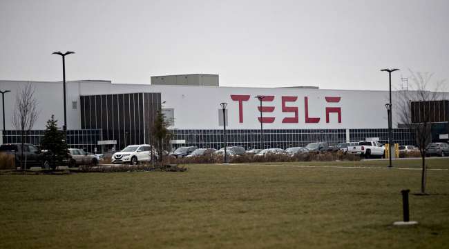 Vehicles sit parked outside the Tesla solar panel factory in Buffalo, N.Y., in 2018.
