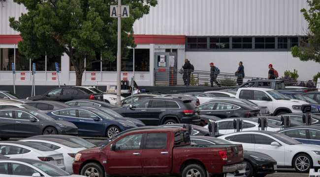 People enter the Tesla assembly plant in Fremont, Calif., on May 11.