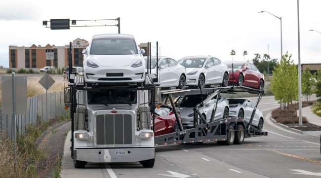 A car trailer carrying Tesla vehicles drives out of the company's assembly plant in Fremont, Calif., on May 11, the day CEO Elon Musk said it would resume production.