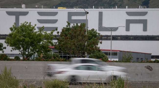 Vehicles pass the Tesla assembly plant in Fremont, Calif., on May 11.